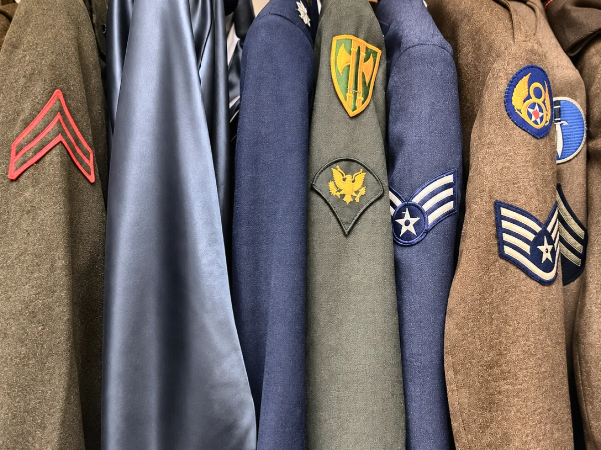Rack of military uniforms showing Eighth Air Force, Military Police and Air Force insignia