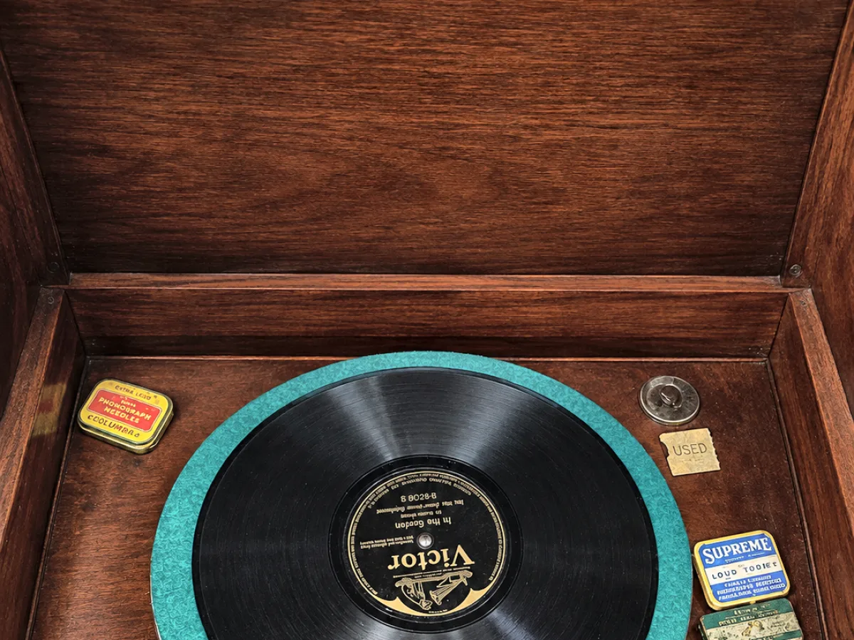 Open Grafonola lid showing a record on the turntable and a typed provenance card
