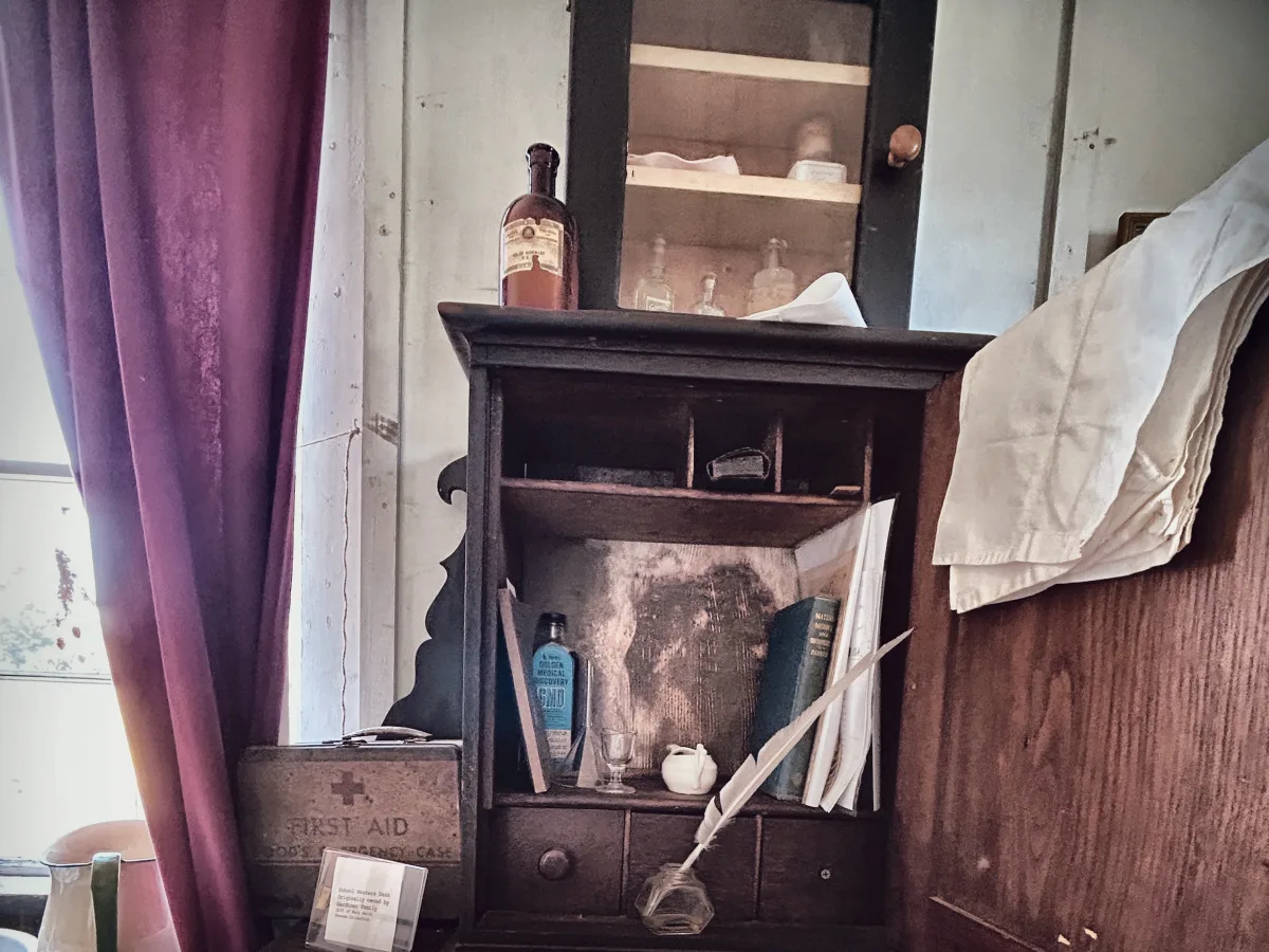 School master&rsquo;s desk with quill, inkwell, medicine bottles and an open medical book