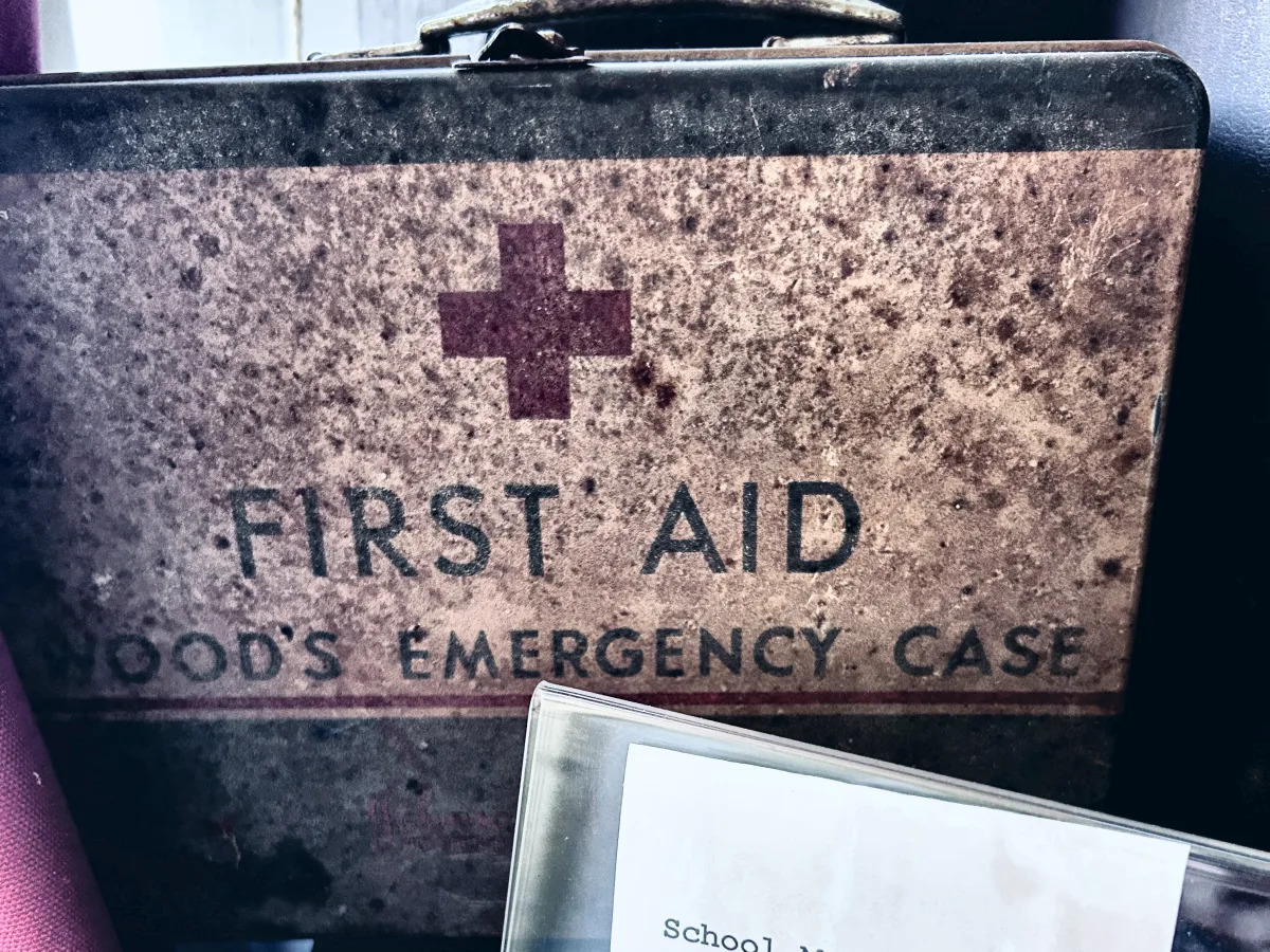 Metal first aid case marked Wood&rsquo;s Emergency Case beside a typed label